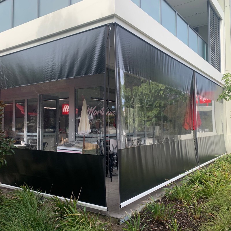 Corner of an outdoor area fully enclosed with clear PVC blinds