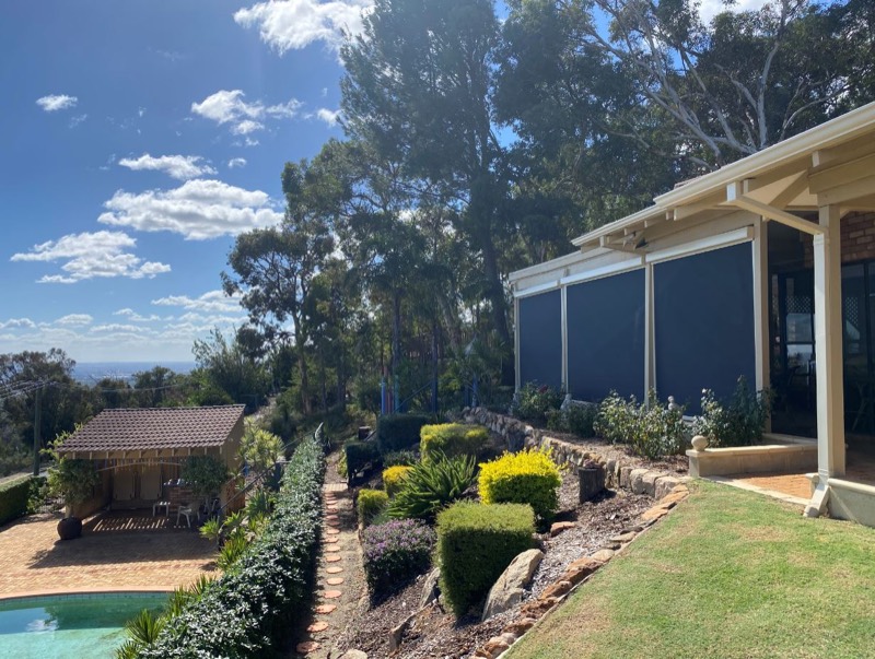 Home in the Perth Hills with outdoor blinds partially lowered, facing bushland and a valley